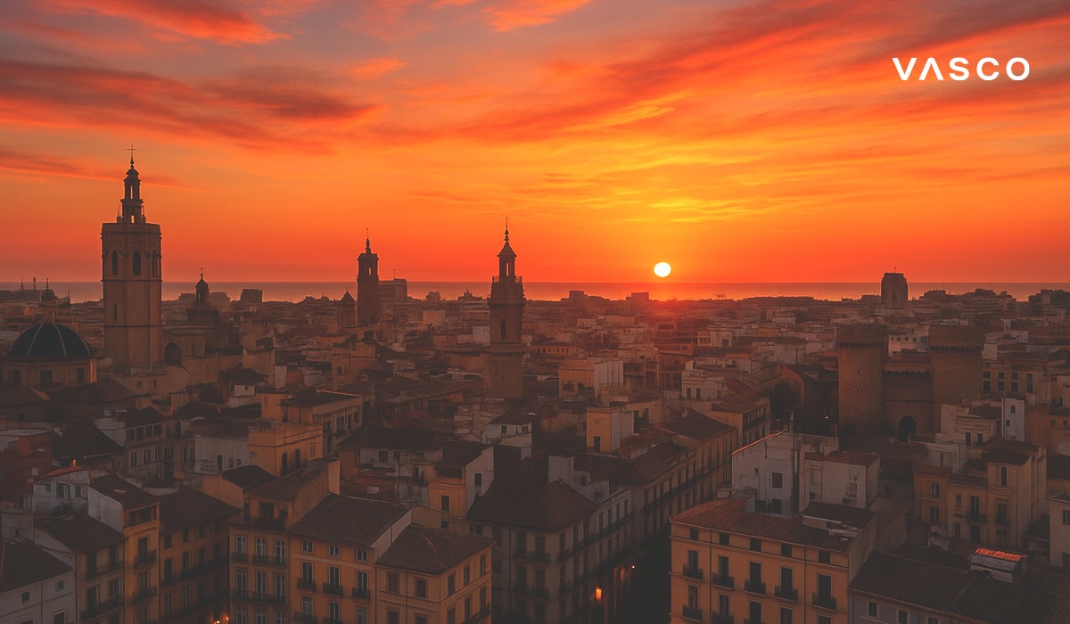 Въздушен изглед на Валенсия, Испания при изгрев слънце с исторически кули и покриви под драматично оранжево небе.