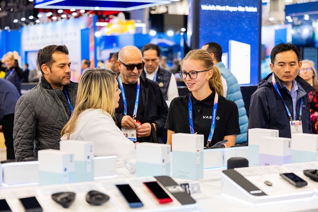 CES 2026 Усмихната група хора разговарят на щанда на Vasco Electronics на CES 2026.