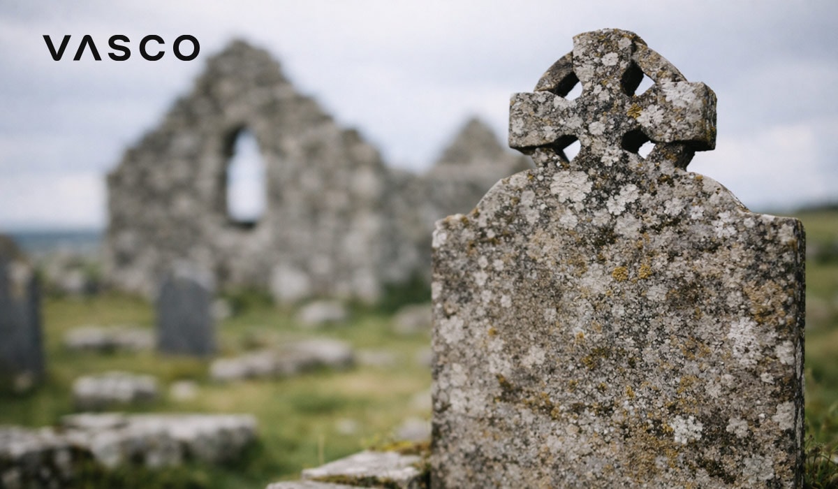 стар надгробен камък с келтски кръст близо до древни каменни руини