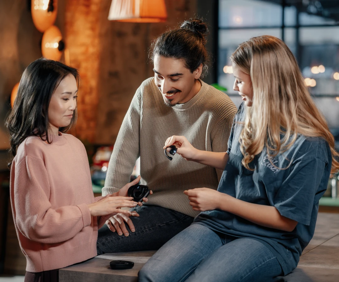 group of multilingual, young, smiling people communicate using earbuds