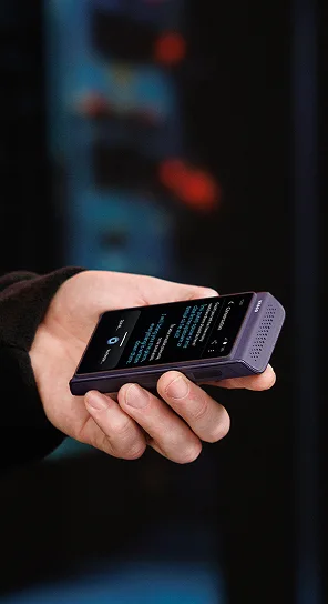 Човек, държащ Vasco Translator Q1 в ръка.