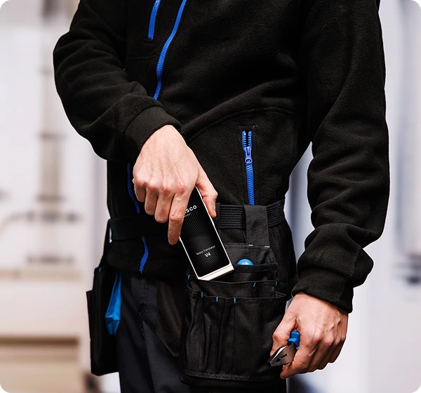 Мъж в работно облекло вади Vasco Translator V4 от колана си с инструменти.