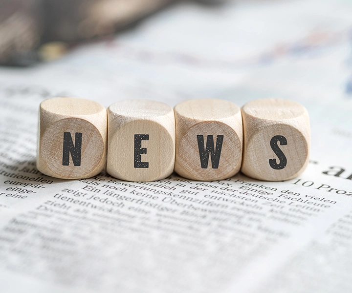 Блокове с надпис „NEWS“, разпръснати върху вестник.